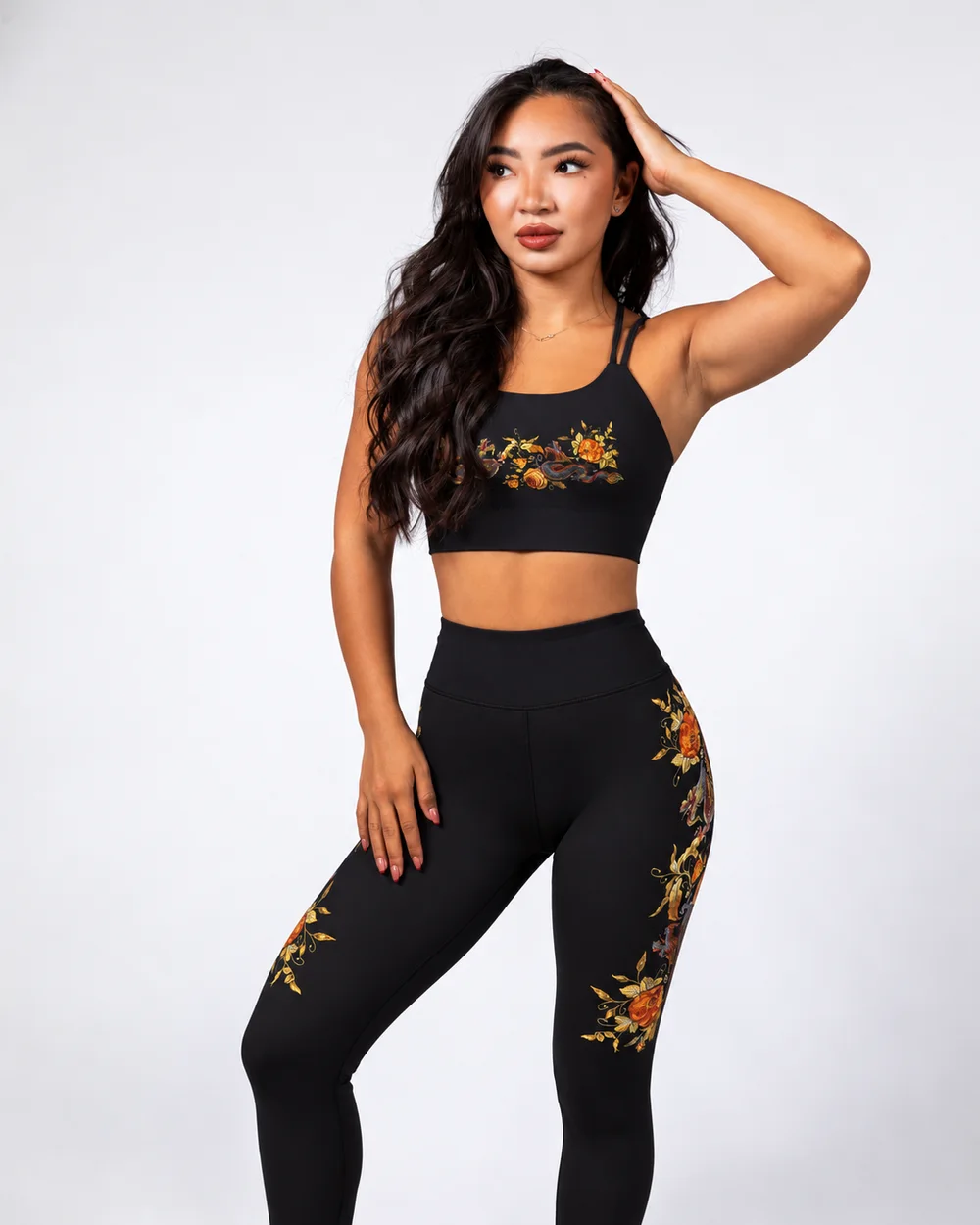 Model in the Dragon Gold set — black bra and leggings with gilded dragon and amber rose embroidery