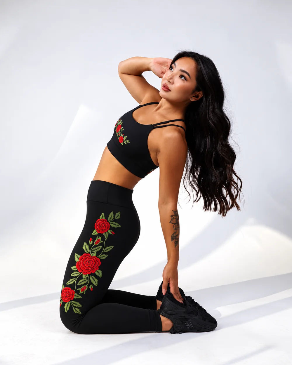 Model kneeling in the Rosa Rouge set with red rose embroidery up the leg