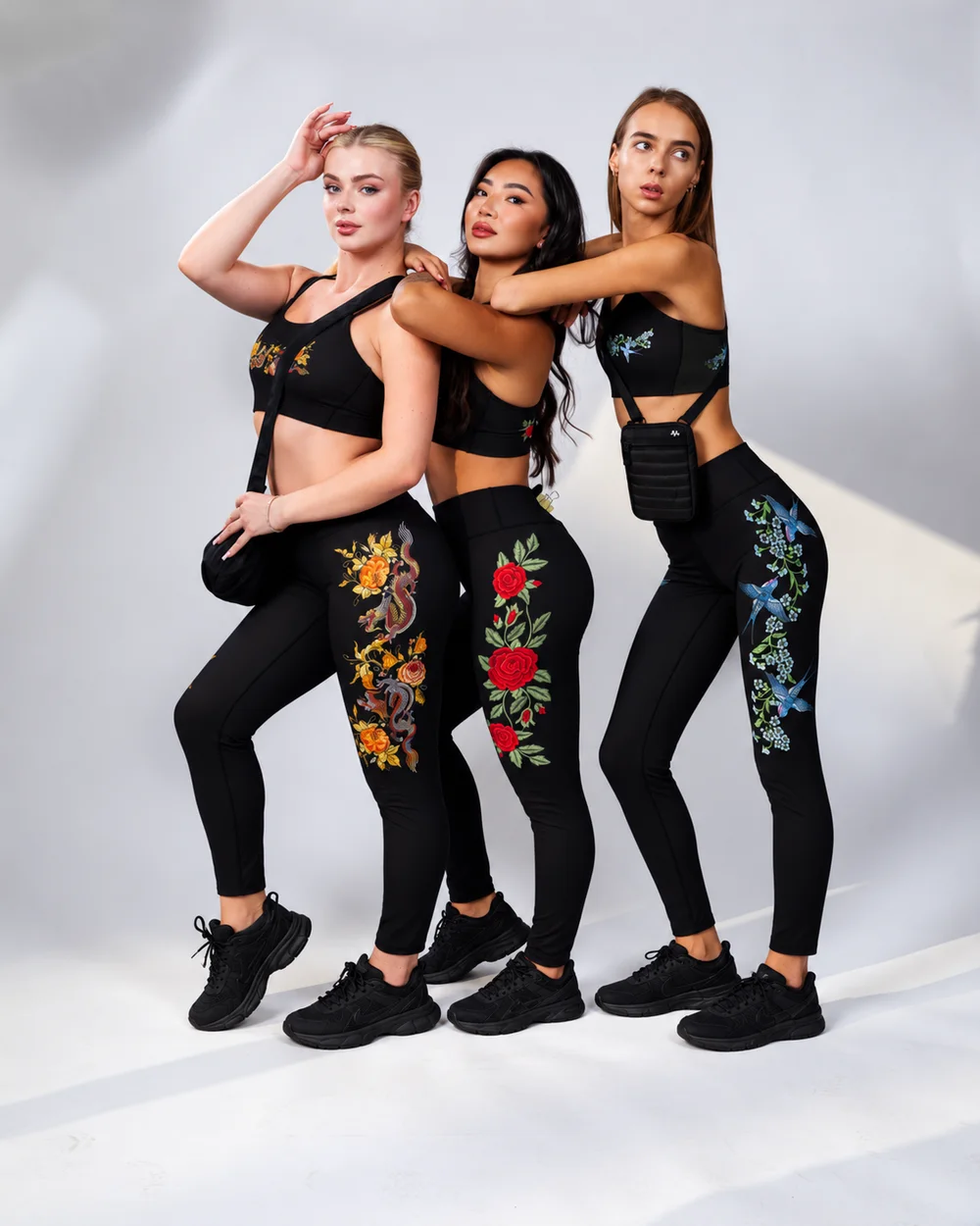 Three models in embroidered ABIRA sets, one wearing the Crescent Crossbody bag